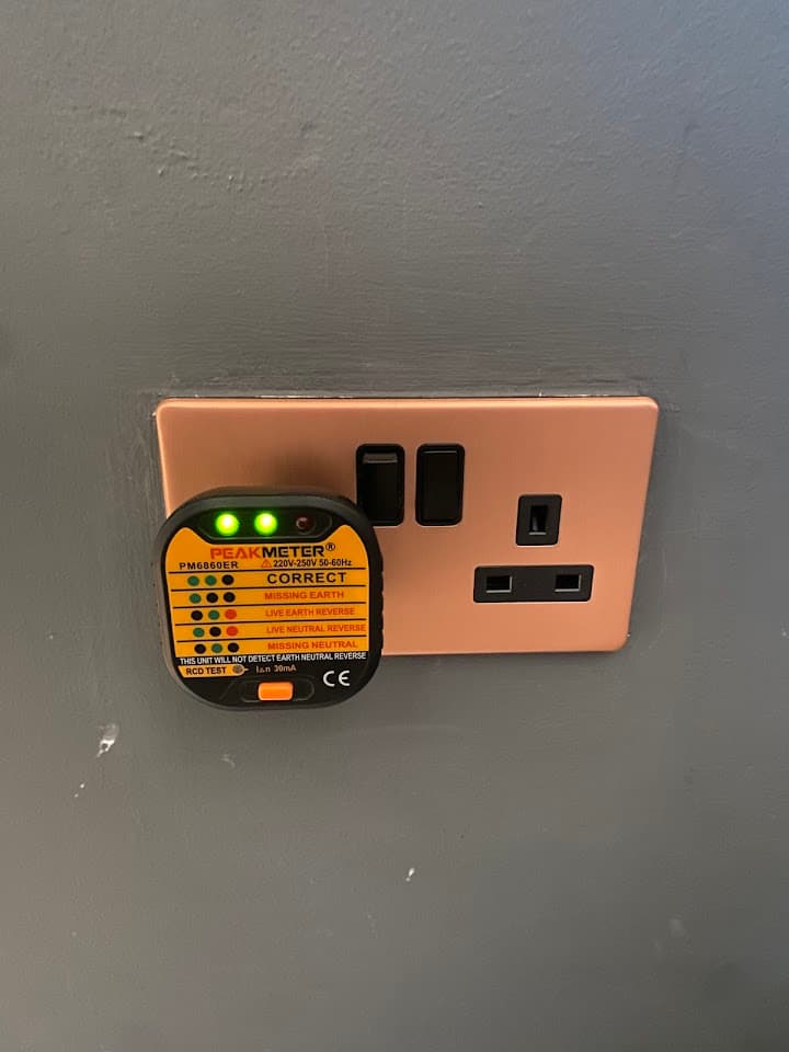 A plug-in socket tester confirming a newly fitted socket is wired correctly