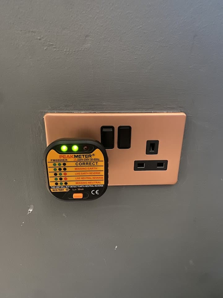 A plug-in socket tester confirming a newly fitted socket is wired correctly